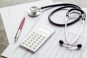 Health insurance concept. Stethoscope near financial documents and calculator