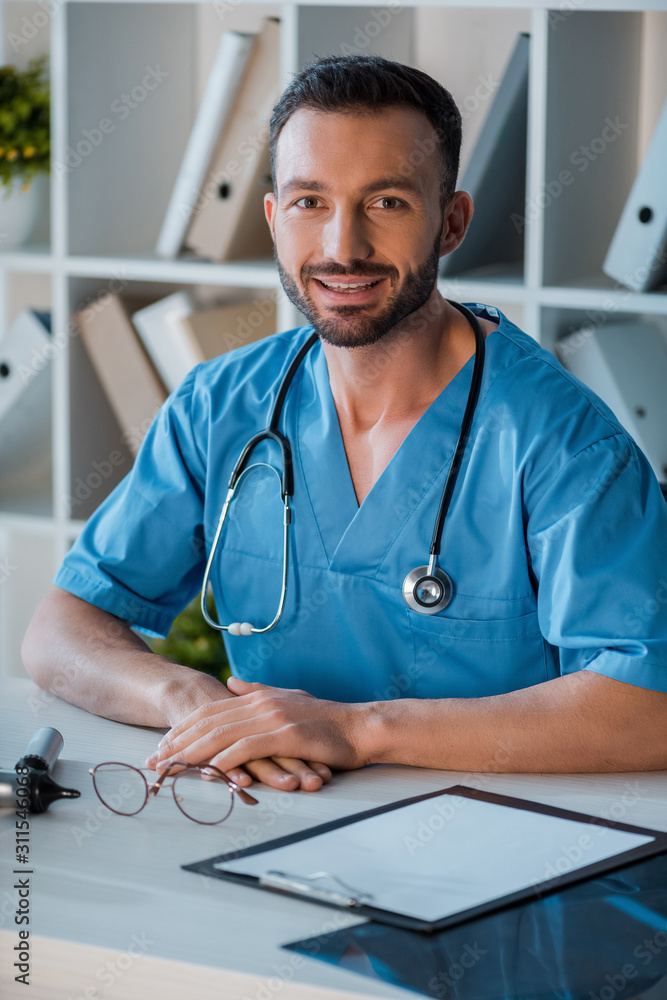 Wall mural cheerful doctor looking at camera in clinic