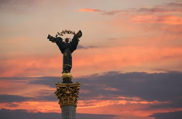 Fototapeten A column with a statue of a woman against a dramatic sky. The symbol of Kiev. Independence Square. © Aleshchenko