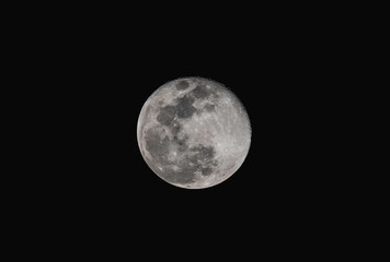 Full moon over dark black sky at night with telephoto lens isolated on transparent background.