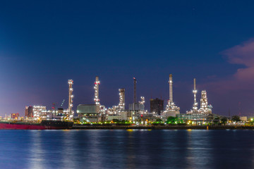 Oil refinery industry plant on blue sky at night at beside Chao Phraya river, Thailand. 