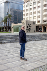 Senior man with a beard walking in the city