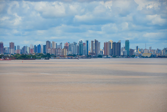 View Of City Belem From The Para River. Many Skyscrapers And Brown Color Water.