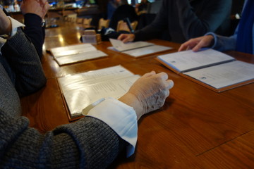 Cropped image of people reading a restaurant menu and choosing something to eat and drink
