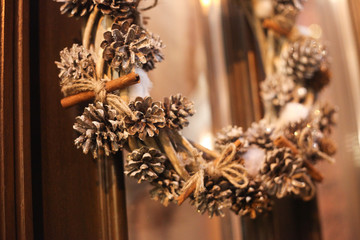 Christmas wreath hanging outside on door in winter made of tree branches, decor, balls and ribbons