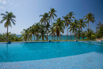 Fototapeta na wymiar An infinity pool among palms on the beach over the Pacific Ocean, Las Perlas archipelago, Panamá, Central America