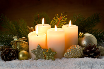 Four burning advent candles and Christmas decoration.