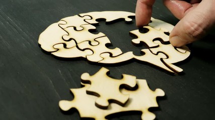 A man is assembling a brain model from puzzles. Treatment of memory and Alzheimer's disease.