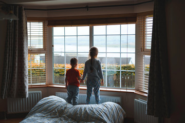 children looking through window at room