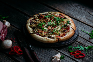 Pizza with ham, mushrooms and cheese on the table