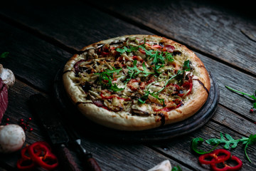 Pizza with ham, mushrooms and cheese on the table