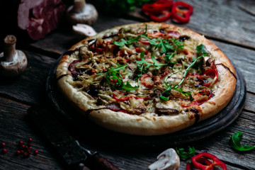 Pizza with ham, mushrooms and cheese on the table