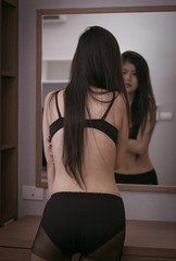 Sexy woman standing in the mirror