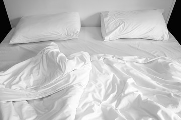 pillows on messy bed with wrinkle duvet