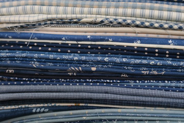 stack of pieces fabric many pattern on shelf, material recycle for clothing fashion design