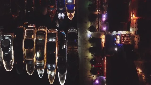 Night aerial shot of luxurious yachts anchored in small bay at old town Hvar in Croatia