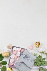 white and pink candy in form of hearts in box , flowers, decoration , gifts and ribbon on white background.