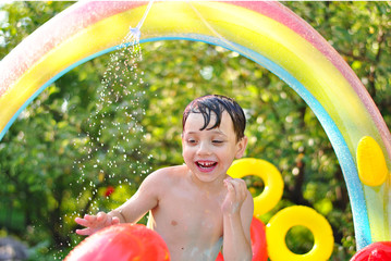 Summer kid photo under the sunshines in childish swimming pool. Kids fun and playing. Enjoy summer...