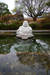 portrait of a white buddha statue on a lake, park with trees in the background, Seoul, Sout Korea, Asia