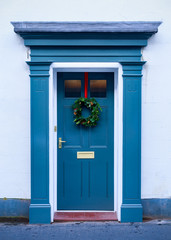 Fototapeta na wymiar Christmas holiday wreath on beautiful entrance door