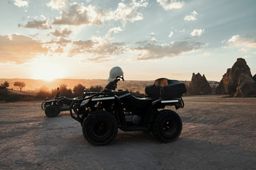 Quad ATV parked on sand without drivers on sunset background in Cappadocia Turkey