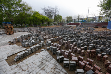 Repair work. Street pavers piled up in piles in a park in open air.