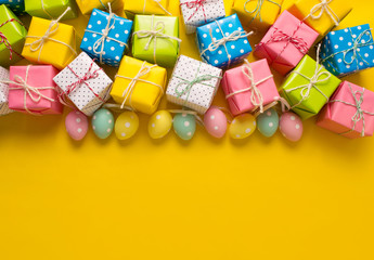 Easter holiday background. Pastel coloured decorated easter eggs on a bright yellow background