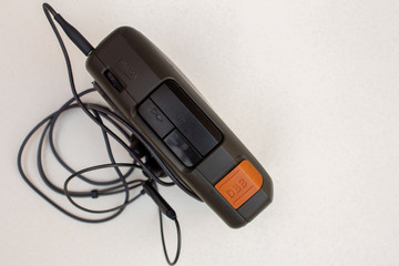 View of the controls in a vintage personal stereo player and the earphones. Portable cassette player.