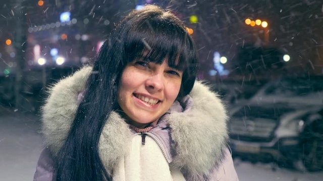 Beautiful Girl Smiling Under Heavy Snowfall. Young Adult. Cold Winter Night. City