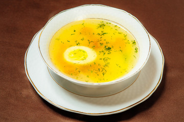 chicken soup with egg in a white plate