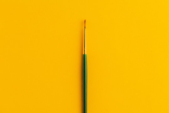 Paintbrush Isolated On Dark Yellow Background