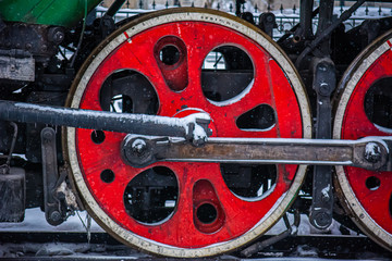 New Year's steam engine in the winter. Close-up of an old snow-covered steam locomotive. New Year Railway