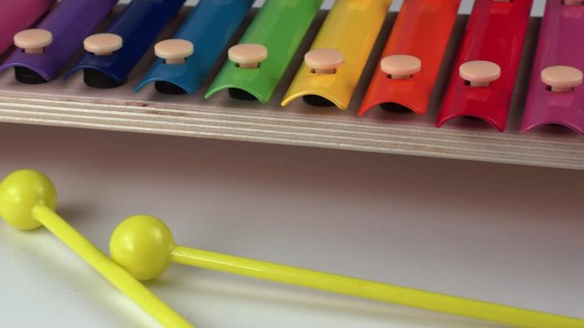 Children xylophone painted with rainbow colors on a white background. Close-up