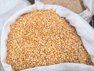 Yellow half peas for organic dietary food. Soup ingredient. Yellow dry peas background with selective focus. Yellow peas in a textured bag. half yellow dried peas
