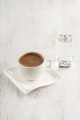 Turkish coffee served with a glass of water on table