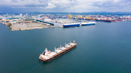 Fototapeta na wymiar shipping logistics business by the sea and terminal storage container ship with industrial city background aerial view from drone camera