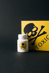 Jar and yellow toxic sign isolated on black