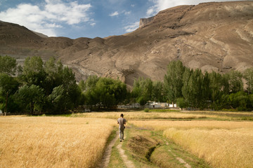 View on the mountains with a man walking wotards it in the village at the Pamir highway in Tajikistan