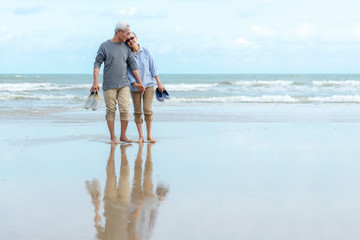 Lifestyle asian senior couple happy walking hug and relax on the beach.  Tourism elderly family travel leisure and activity after retirement in vacations and summer. - Powered by Adobe