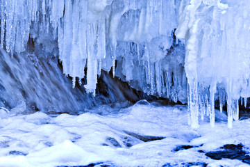 Snow covered icy blue waterfall for postcard