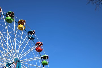 Ferris wheel in an amusement Park against the blue sky