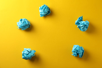 Paper balls on yellow background, space for text