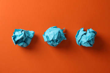 Paper balls on orange background, space for text