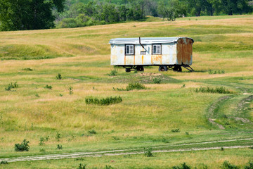 Fototapeta na wymiar a lone container on wheels in a field for poor people to live in outside the city