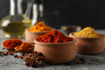 Bowls with spices and ingredients on grey background, space for text