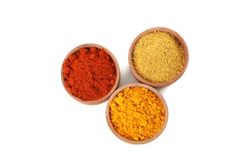 Wooden bowls with red pepper, curry and turmeric powder isolated on white background