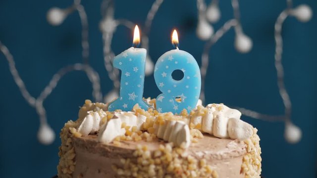 Birthday cake with 19 number candle on blue backgraund. Candles blow out. Slow motion and close-up view