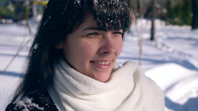 Close-up Pretty Female Face. Snowflakes On Hair. Young Adult In Snow Covered City Park On Sunny Day. Slow Motion 30 fps 0.5 normal speed 60 fps