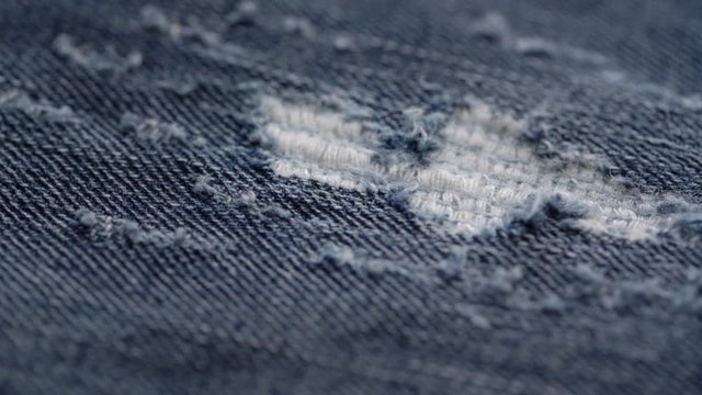 shabby denim cloth with blue and white threads of special disheveled patches design rotates extreme close view