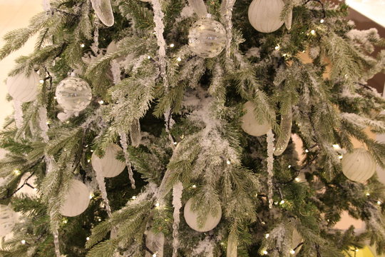 new year fir tree decoration with snow, frost, balls, icicles, christals, lights